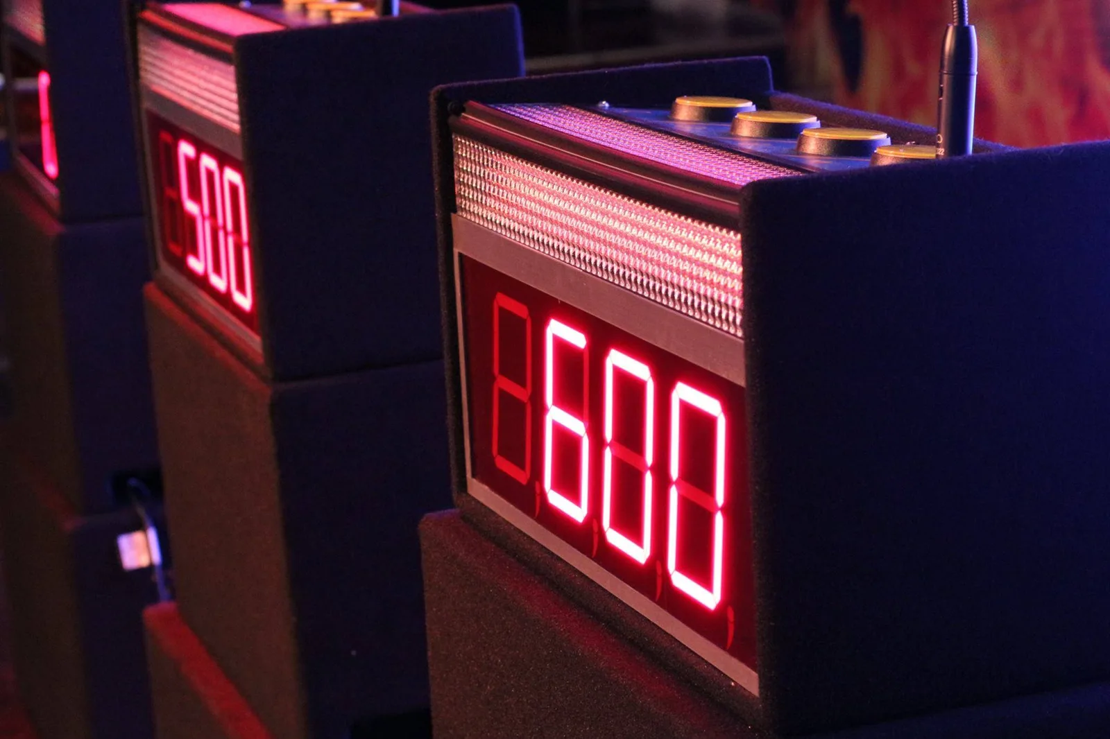 Illuminated game show buzzer podiums with digital score displays